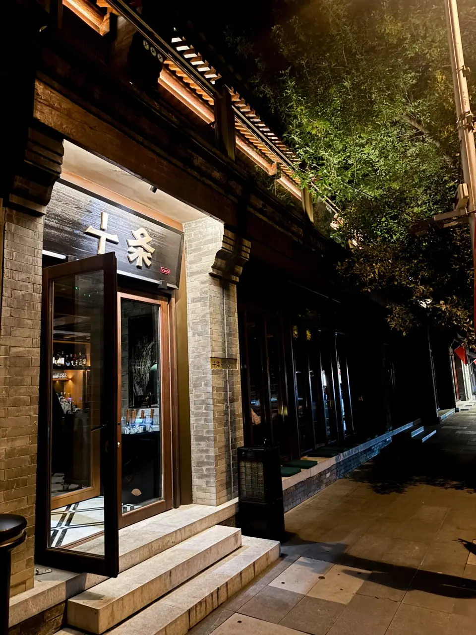 Street entrance of TIAO bar in Beijing with trees and outdoor seating