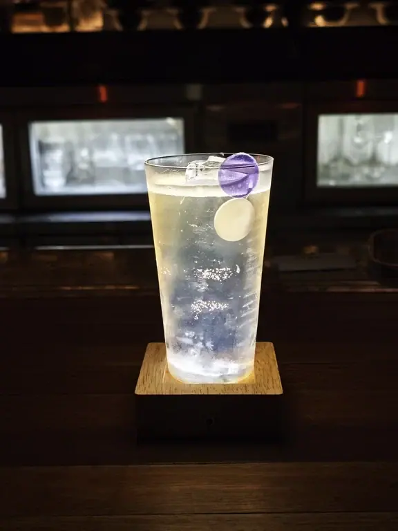Tall cocktail garnished with lime on the wooden counter at Flavor Tiki in Chongqing