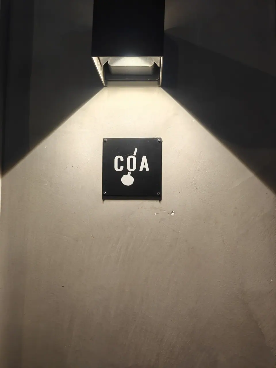 Illuminated COA sign on a wall at the Shanghai bar