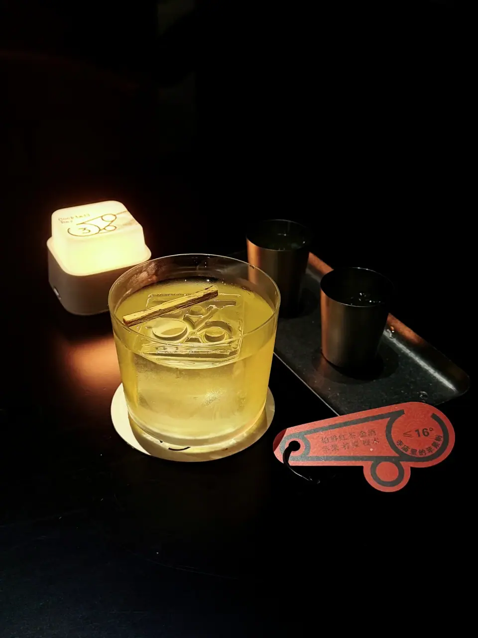 Pale cocktail beside an illuminated 3% sign at 3 Percent bar in Guilin