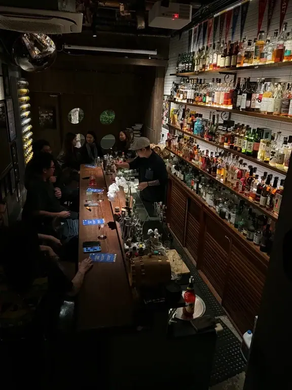 Wooden bar counter and bottle shelves inside Chimney in Hangzhou